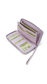 Billetera larga con cierre perimetral, confeccionada en material sintético con estampado botánico de flores silvestres sobre fondo claro. Cuenta con múltiples compartimentos internos para tarjetas, visor para documentos y un bolsillo interno con cierre. Incluye una correa de mano extraíble.