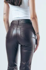 Pantalón de tiro alto confeccionado en eco cuero, con corte tipo oxford ajustado en la parte superior y ligeramente acampanado hacia el ruedo.