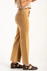 Jean de tiro alto con corte wide leg y acabado lavado en tono camel. Presenta diseño de cinco bolsillos, cierre frontal con botón y cremallera, y bajo con terminación al corte.