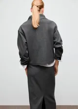 Jersey de cuello alto con cierre de cremallera corta y manga larga, de diseño amplio y color gris oscuro.