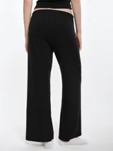 Pantalón de dormir de corte recto y holgado, confeccionado en tejido suave con textura acanalada. Presenta cintura elástica con cordón ajustable y bolsillos laterales.