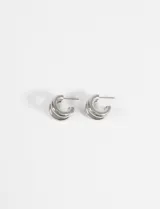 Aros tipo argolla de diseño doble, confeccionados en acero quirúrgico hipoalergénico con acabado brillante.