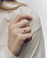 Anillo de oro con diseño ondulado y pequeños cristales incrustados.