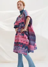 Poncho tejido con cuello alto y aberturas laterales, con diseño geométrico multicolor en tonos rosa, azul y violeta.