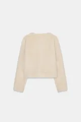 Chaqueta de cuello redondo y manga larga con tejido exterior efecto pelo e interior efecto ante. Presenta bolsillos delanteros de vivo y cierre frontal con alamares metálicos.