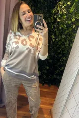 Buzo de lanilla con estampado animal print en la parte superior, cuello redondo y mangas largas con puños en contraste. Presenta un diseño degradado con franjas horizontales en la parte inferior.