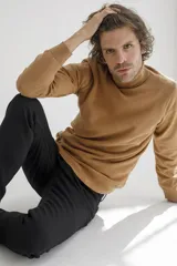 Sweater de cuello alto en color tostado, confeccionado en tejido de punto con textura en el panel frontal y mangas lisas. Presenta puños y ruedo acanalados.