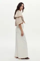 Jean blanco wide leg de tiro alto, con costuras decorativas verticales al frente y pernera ancha.