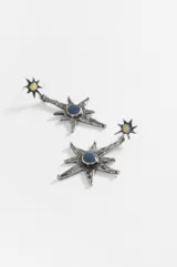 Caravanas colgantes con diseño de estrella de ocho puntas en metal envejecido, con un centro circular azul y un pequeño detalle superior con piedra amarilla.