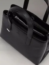 Cartera tipo tote de cuero sintético color negro, con doble asa corta y correa larga desmontable.