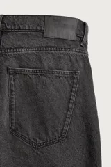 Pantalón de jean corte slim fit, color azul oscuro, con diseño de cinco bolsillos, tiro medio y cierre frontal con cremallera y botón.