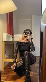 Top de encaje negro con escote bardot y mangas largas. Presenta un diseño ajustado al cuerpo con acabado delicado.