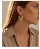 Aros tipo argolla de acero con baño de oro, diseño de doble aro superpuesto con acabado pulido.