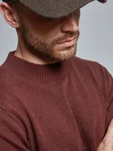 Sweater color borgoña de tejido suave con cuello redondo y calce cómodo.