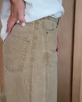 Pantalón de jean azul de tiro medio, con corte wide leg y ruedo deshilachado.