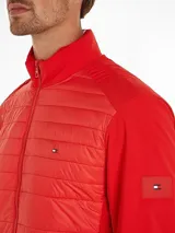 Campera roja con cierre de cremallera, cuello alto y mangas largas. Tiene dos bolsillos delanteros y logo de Tommy Hilfiger en el pecho y en la manga.