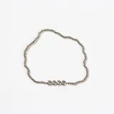 Pulsera de cuentas metálicas plateadas con un detalle central de cuatro piedras brillantes engarzadas.