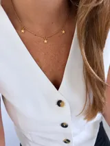 Gargantilla de acero dorado con cadena de eslabones y dijes colgantes en forma de estrella.