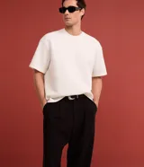 Remera masculina de corte boxy, color marrón oscuro, con cuello redondo y mangas cortas. Confeccionada en malla pesada con textura gomosa.