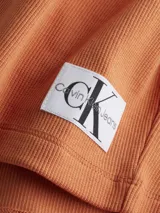 Remera corta color naranja de Calvin Klein Jeans, con cuello tipo chomba de canalé, manga corta y corte holgado.