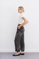 Pantalon tipo palazzo de tiro alto, confeccionado en viscosa estampada con diseño geométrico multicolor. Presenta cierre lateral invisible y bolsillos diagonales.