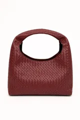 Cartera tipo hobo de cuero sintético bordó, con diseño trenzado y asa integrada.