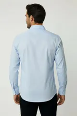 Camisa blanca de algodón, de diseño holgado y manga larga, con cuello camisero y cierre frontal de botones.