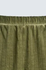 Bermuda de algodón color verde oliva, con corte relajado y textura acanalada vertical. Presenta cintura elástica con cordón interior y bolsillos laterales y trasero.