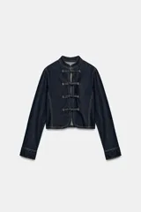 Cazadora de denim azul oscuro, de corte entallado, cuello redondo y manga larga. Cuenta con cierre frontal con alamares y costuras pespunteadas en contraste.