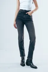 Jean de corte skinny y tiro medio, confeccionado en denim elástico de color gris oscuro con efecto lavado. Presenta diseño clásico de cinco bolsillos, cierre frontal con botón y presillas en la cintura.