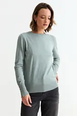 Sweater de punto fino en color verde menta, con cuello redondo, mangas largas y puños acanalados con detalle de botones metálicos laterales.