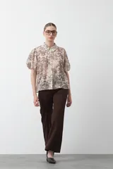 Pantalón ancho de tiro alto, color negro, con pretina y doble botón metalizado.