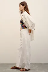Jean blanco de corte barrel, estilo slouchy, con tiro alto y presillas para cinturón.