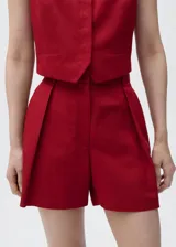 Short de tiro alto color rojo, de diseño recto y estilo sastrero, con trabillas, cierre delantero y bolsillos laterales.