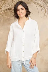 Camisa blanca de lino con cuello mao, mangas 3/4 con botón para sujetar, cierre con botones a tono y ajuste con cordón en la cintura.