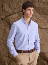 Camisa de manga larga con cuello button down, cierre frontal con botones y bolsillo en el pecho. Presenta un diseño de microestampado sutil en tono azul claro.