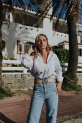 Camisa blanca de mangas largas con cuello clásico y cierre con botones.