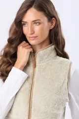 Chaleco de tejido sherpa color beige, con cuello alto y detalles en eco cuero. Diseño sin mangas que proporciona abrigo al torso manteniendo la libertad de movimiento.