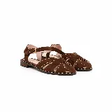 Sandalias chatitas de cuero en color marrón tostado, con diseño de tiras cruzadas en el empeine decoradas con tachas metálicas pequeñas. Cuenta con tira ajustable al tobillo mediante hebilla metálica y taco bajo.