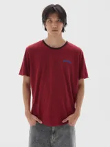 Remera color bordó con cuello redondo y ribete oscuro, manga corta y corte oversized. Confeccionada en algodón lavado para una textura única.