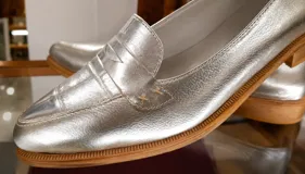 Mocasines de cuero plateado con acabado texturado, diseño clásico con costuras visibles y vira de suela natural cosida. Cuenta con taco plano de 2 cm y plantilla anatómica.
