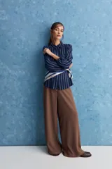Camisa de calce relajado con cuello clásico, mangas largas con puños elastizados y rayas verticales que aportan un estilo atemporal. Su diseño liviano y versátil cuenta con estampado floral verde sobre fondo de rayas celestes y blancas.