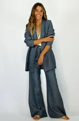 Blazer de lino color azul, con solapa de muesca, cierre frontal de botones y diseño de corte recto y holgado.