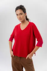 Buzo de punto confeccionado en lambswool, con diseño amplio, escote en V y mangas 3/4. Presenta una combinación de tonos rojos en la espalda con una franja central ancha y tajos laterales.