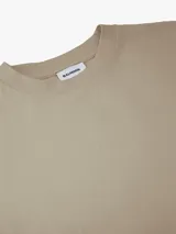 Remera de manga corta color beige, con ajuste relajado y corte estructurado.