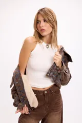 Campera de jean con diseño de estampado paisley en tonos marrones y grises. Presenta un corte relajado, cuello camisero, cierre frontal con botones metálicos y bolsillos frontales con solapa.