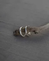 Anillo tipo alianza abierta de diseño irregular y orgánico, confeccionado artesanalmente en plata 925.