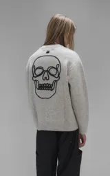 Sweater de cuello redondo color gris melange, con diseño de punto texturado y bordado en relieve con las letras 'Lx.' en el pecho. Presenta terminaciones en punto rib en cuello, puños y ruedo.