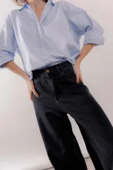 Jean wide leg de tiro medio y corte holgado con piernas muy anchas, confeccionado en denim de lavado azul medio.