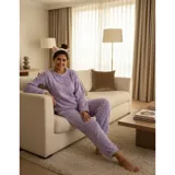 Pijama de dos piezas de tejido plush texturado con diseño de puntos en relieve, compuesto por un buzo de manga larga con cuello redondo y un pantalón largo de corte recto.